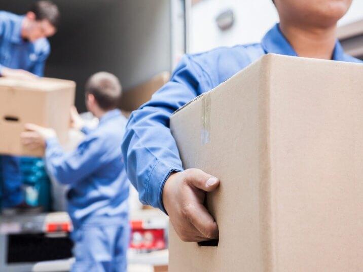 movers carrying heavy furniture into a new home